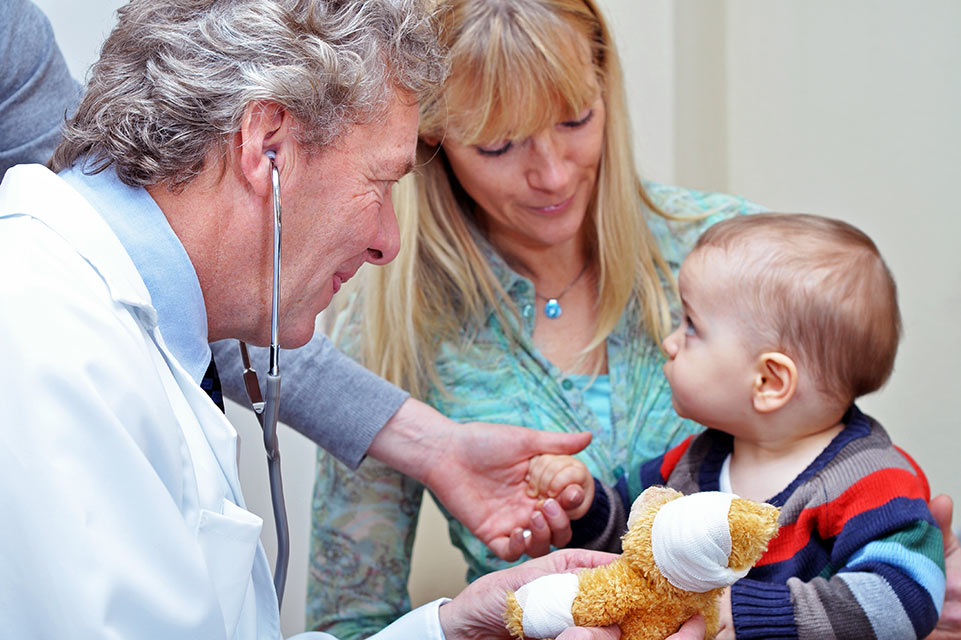 médico examinando a un paciente con su madre