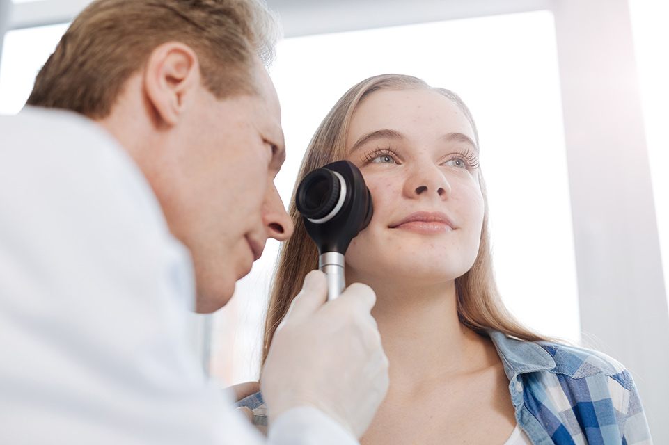 dermatólogo examina la cara de un paciente