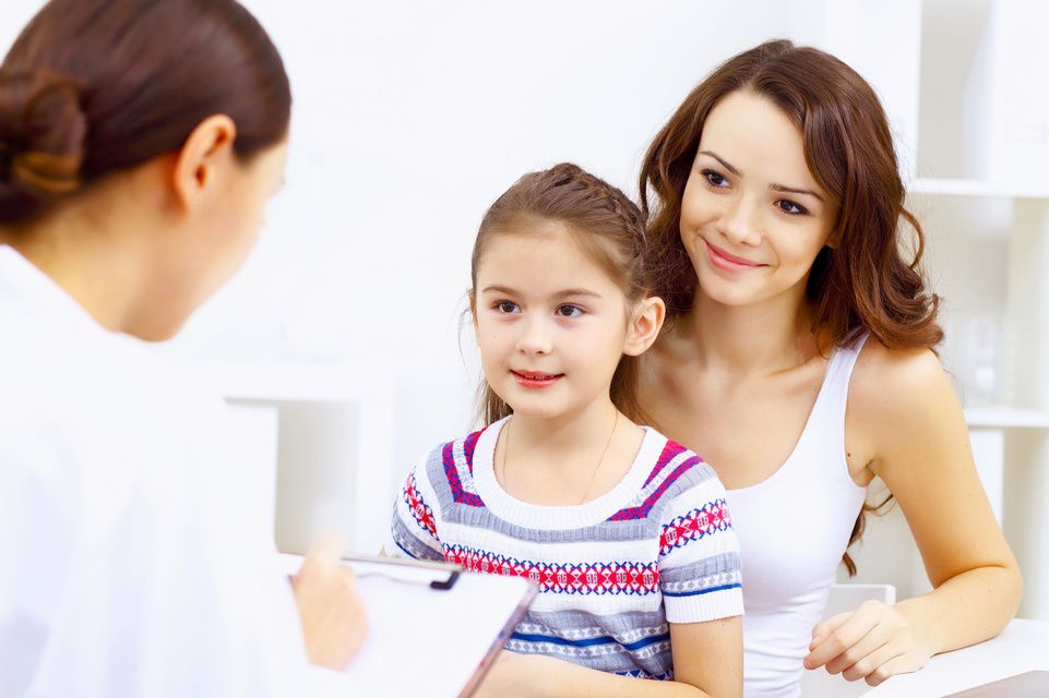 patient sitting on mom lap talking to physician