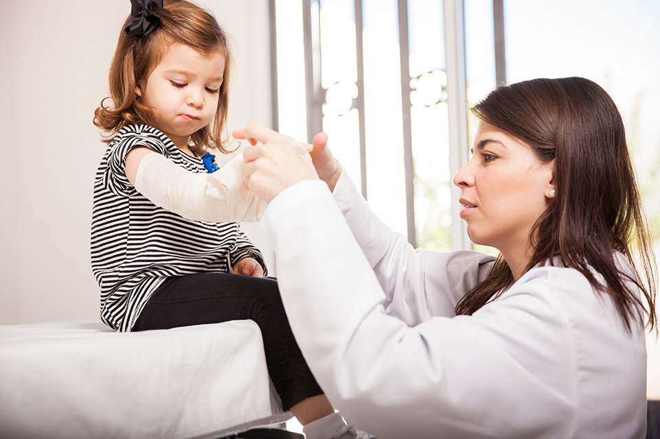 physician bandaging female patient arm