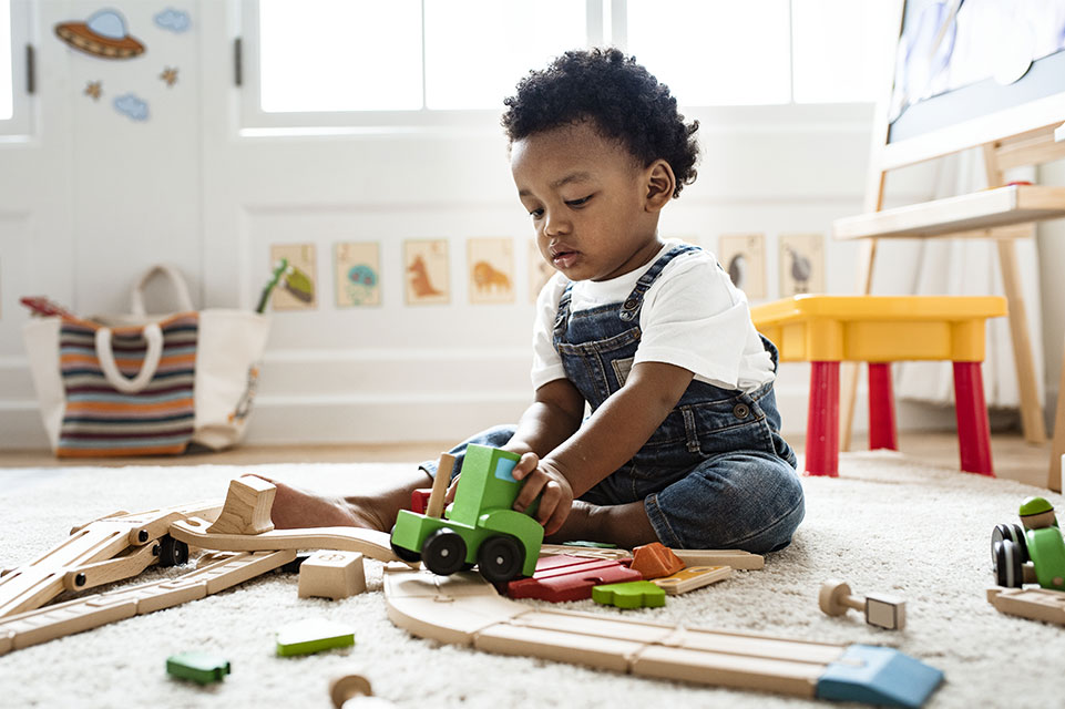 niño pequeño jugando con un tren