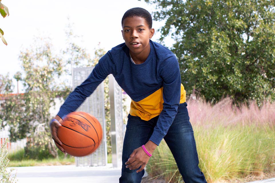 Un adolescente jugando al básquetbol