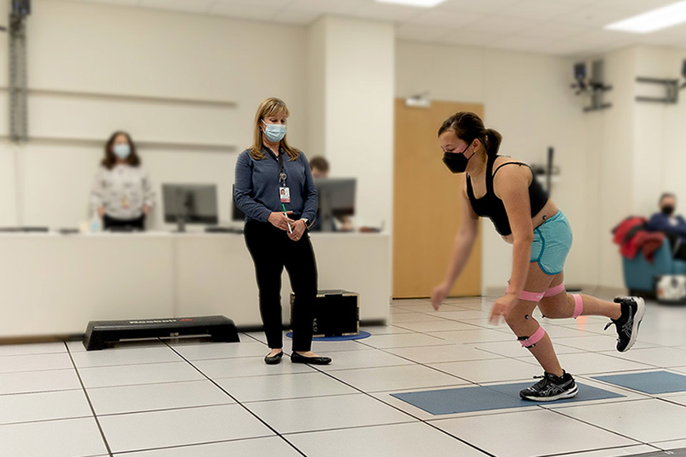 Female patient testing movements with staff