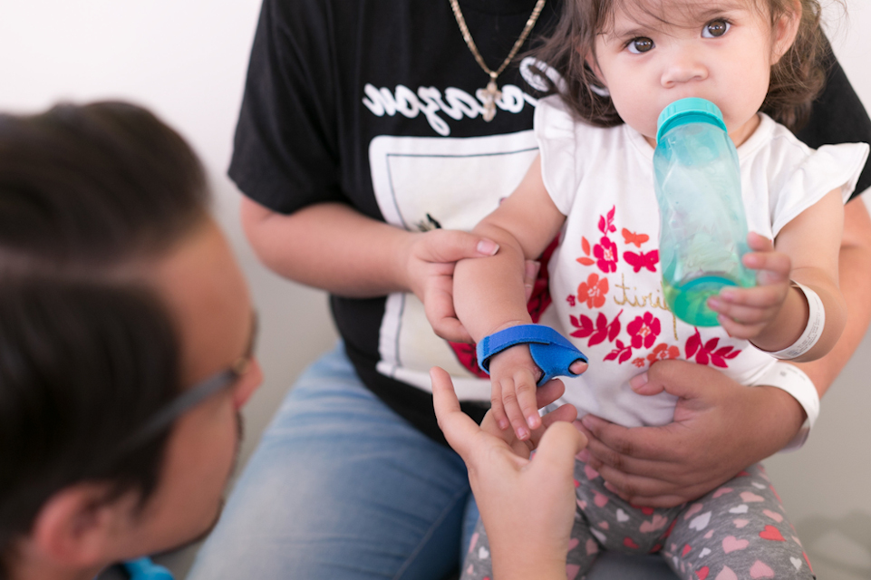 un bébé assis sur les genoux en train de manger