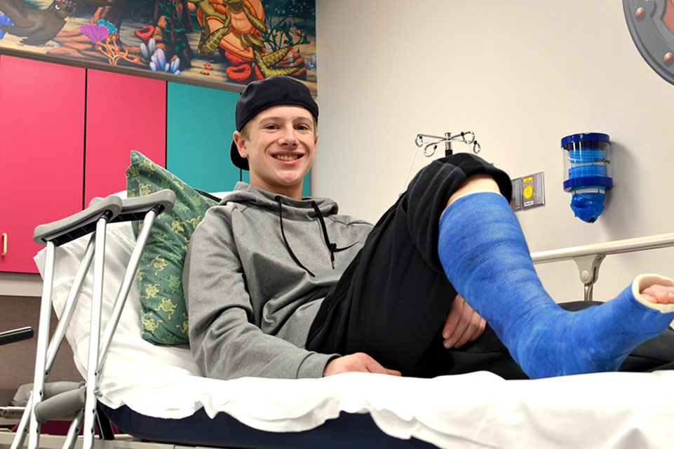 patient wearing cast, sitting on exam table