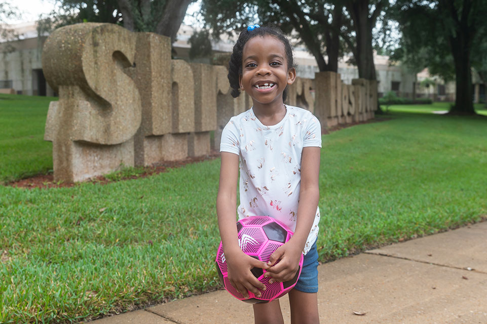 female knock knees patient holding soccer ball