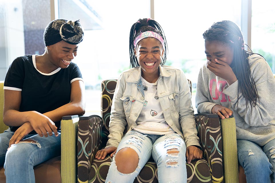 three teen girls laughing