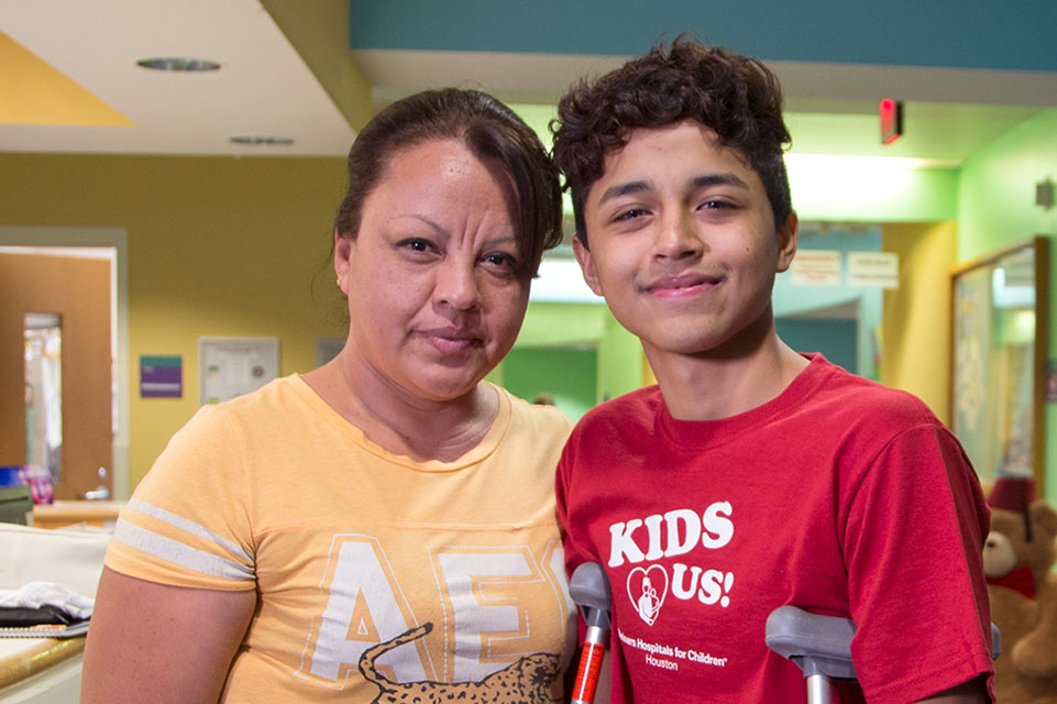 mom and patient on crutches in hospital hallway