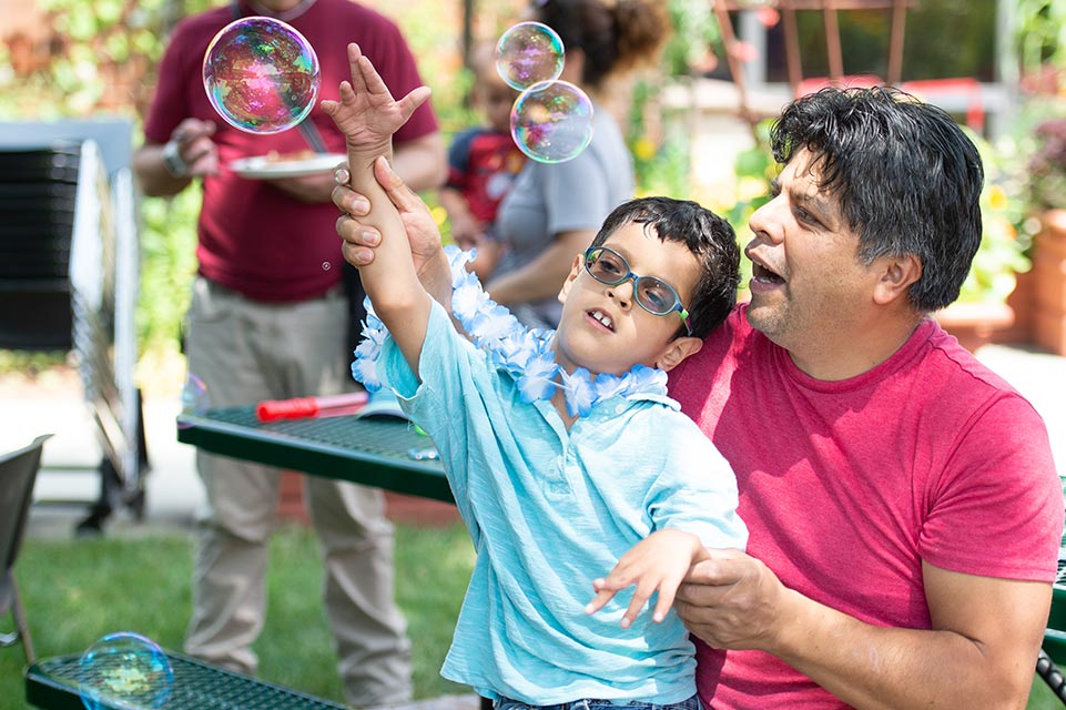 un patient et son père jouant avec des bulles