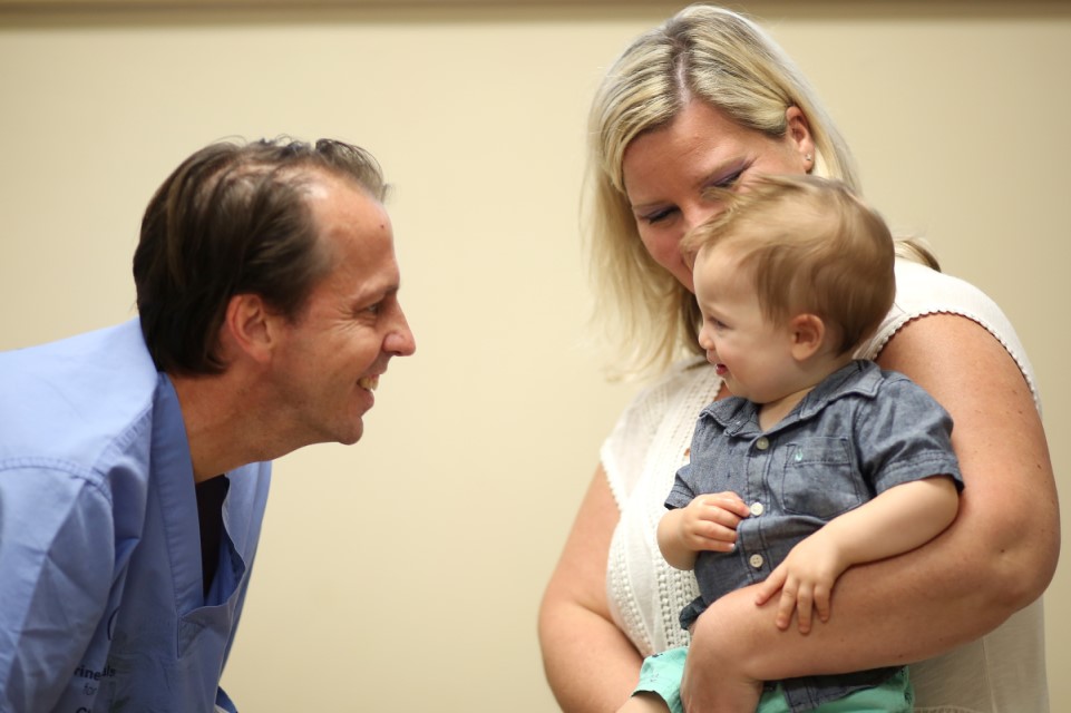 mom holding baby patient, provider interacting with patient