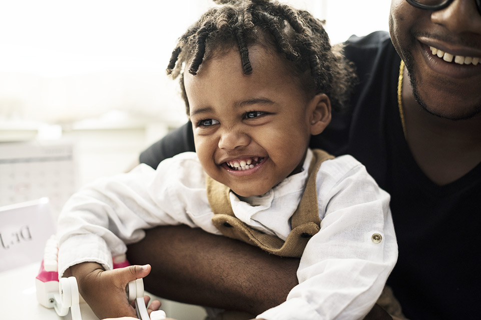 father holding smiling male patient