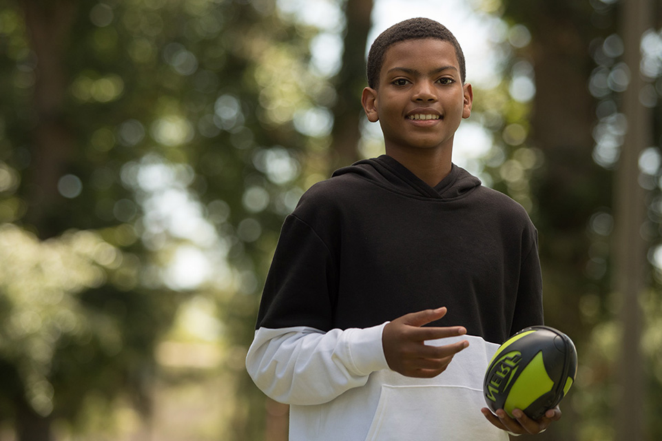 male patient playing football outside