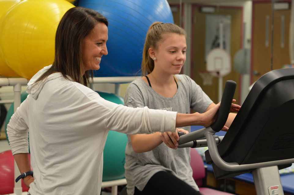 un physiothérapeute travaille avec un patient sur un tapis roulant