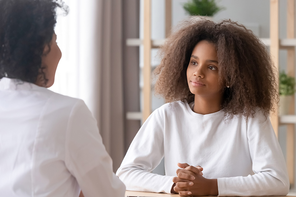 physician speaking with teen female patient