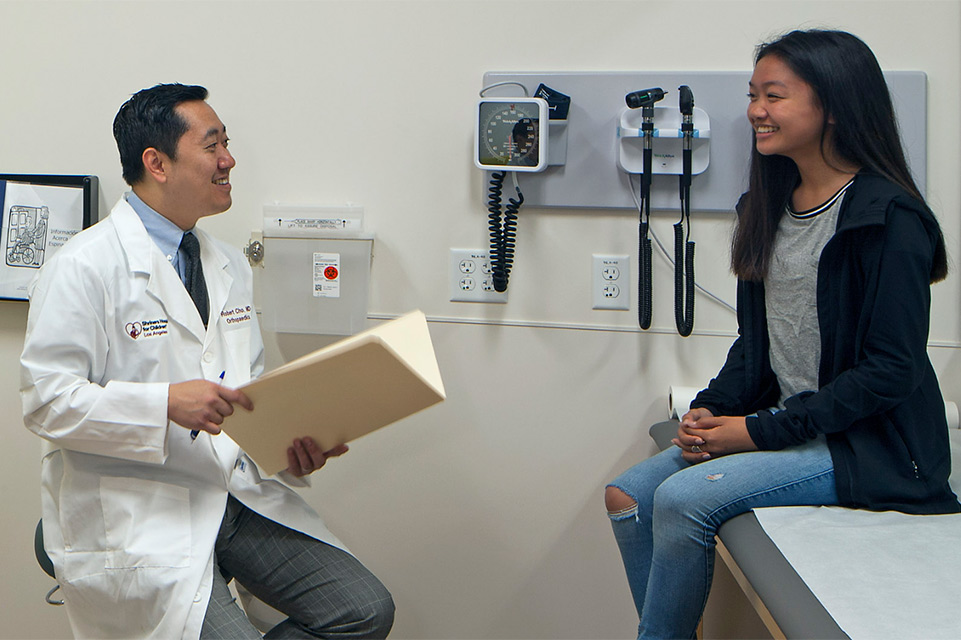 physician and female patient during spondylosis exam