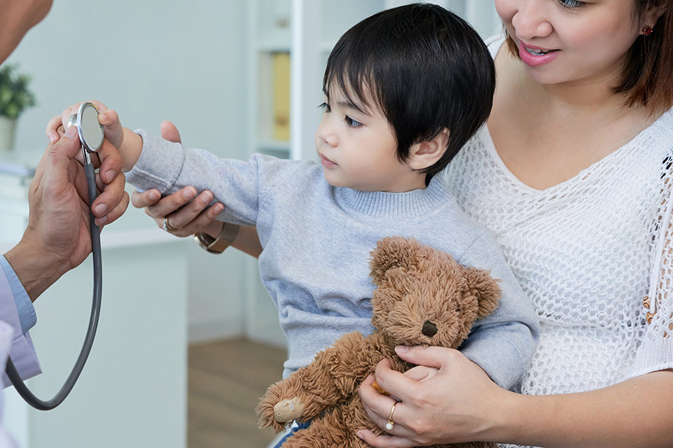 parent holding patient while interacting with physician