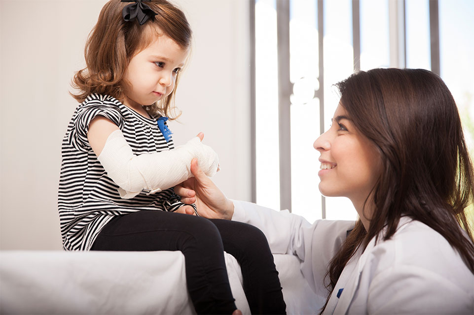 médico y paciente con un brazo vendado