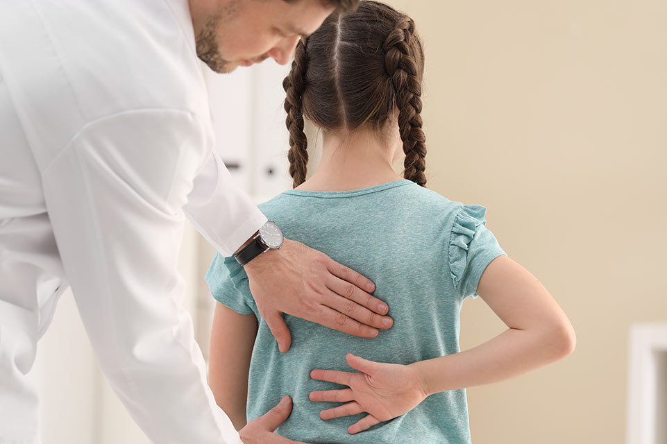 médico examina la columna vertebral de un paciente