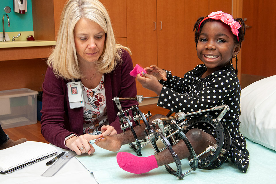 patient wearing external fixator, physician