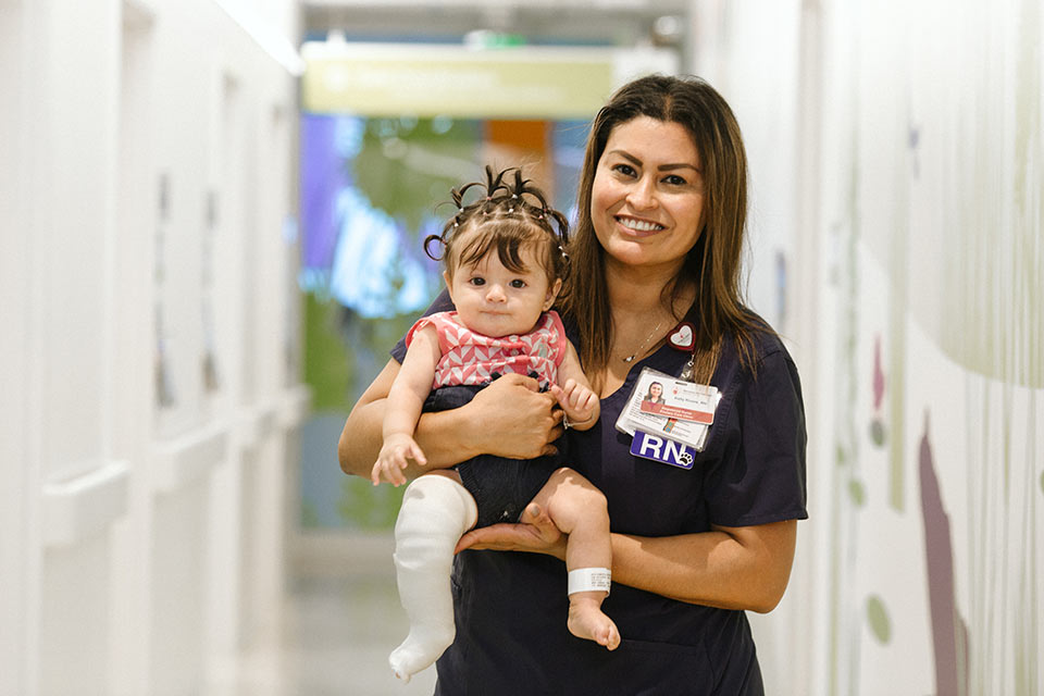 Female nurse holding female infant