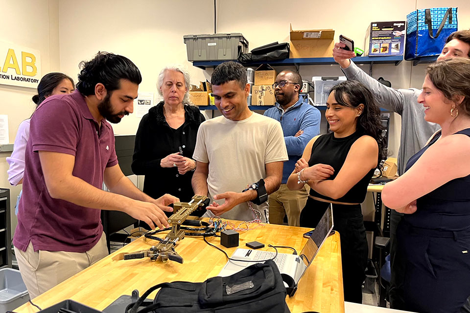 Adult students watching male technician demonstrate equipment usage