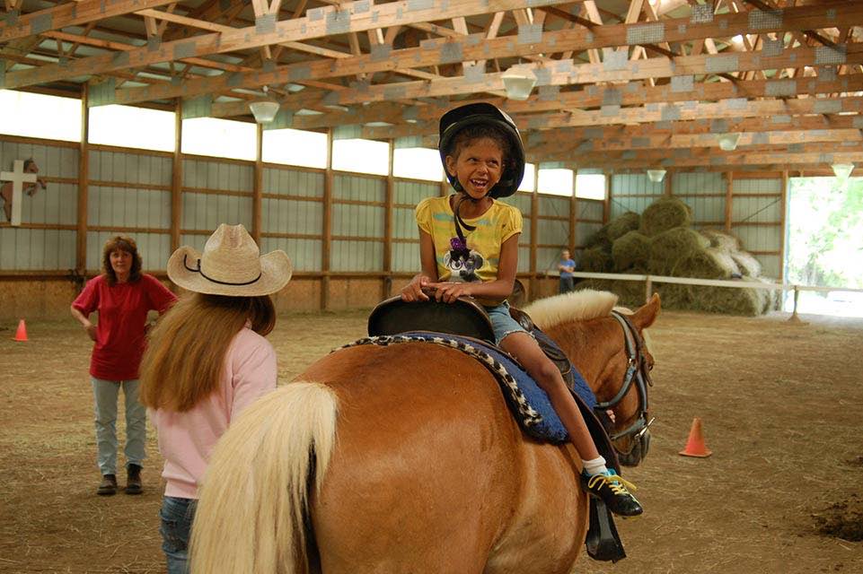 Petite fille assise sur un cheval