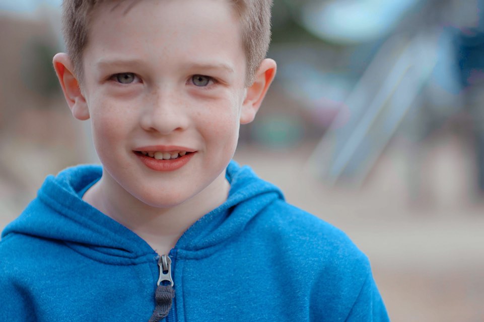 Boy in blue hoodie smiling 